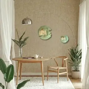 Minimalistisches Esszimmer im Wabi-Sabi-Stil mit rundem Holztisch, Wishbone-Chair und zwei hellgrünen Kintsugi-Teller mit goldenen Reparaturlinien als Wandkunst auf einer strukturierten Tapete.